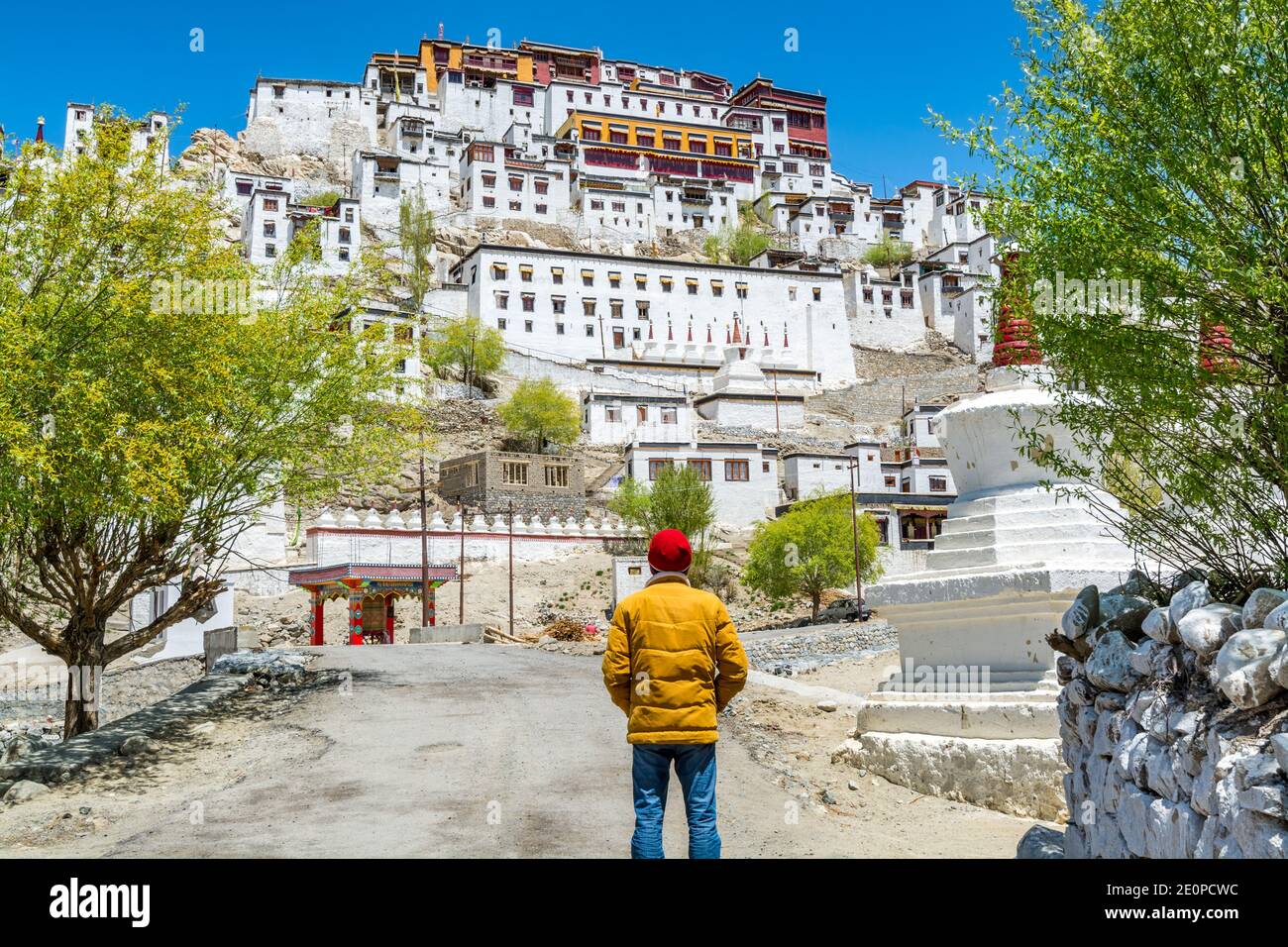A male tourist standing in front of Thiksey Monastery or Thiksey Gompa, A famous Tibetan temple in Ladakh, India Stock Photo