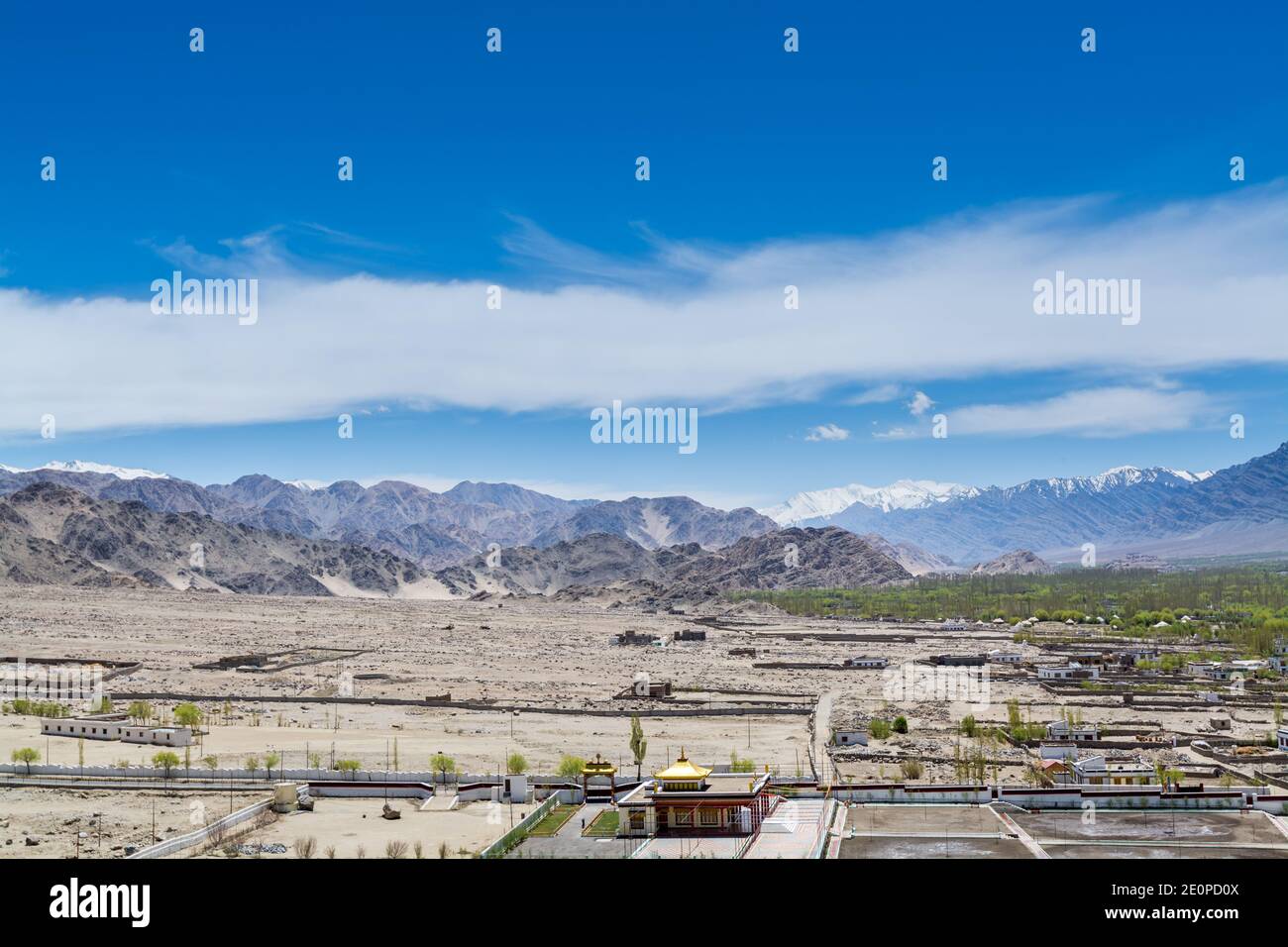 Beautiful landscape with fields, Tibetian buildings, snow mountains, and blue sky,  in Ladakh, Kashmir, view from Thiksey Monastery or Thiksey Gompa Stock Photo