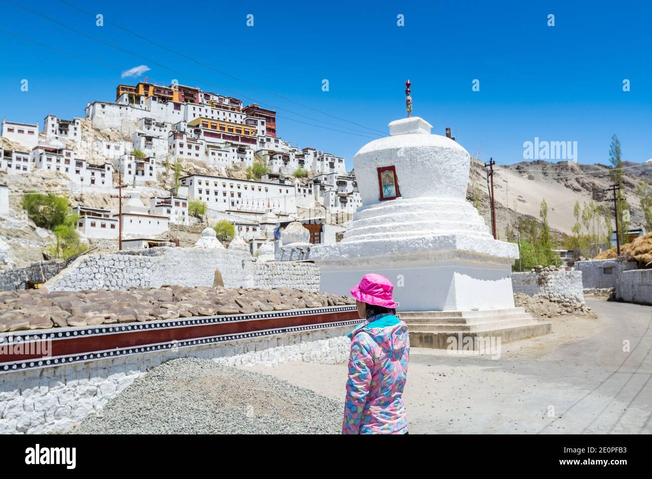 A Chinese female tourist standing in front of Thiksey Monastery or Thiksey Gompa, A famous Tibetan temple in Ladakh, Kashmir Stock Photo