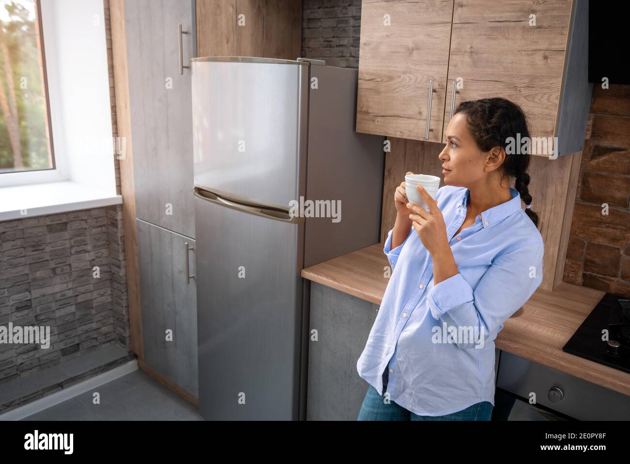 Woman looks out window drinks hi-res stock photography and images - Alamy
