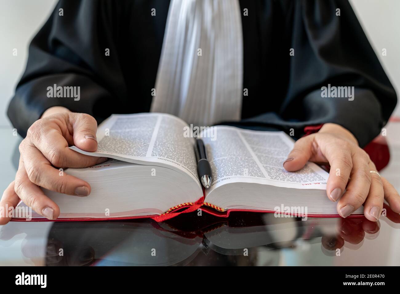 Justice, lawyer woman holding and reading open red law book French