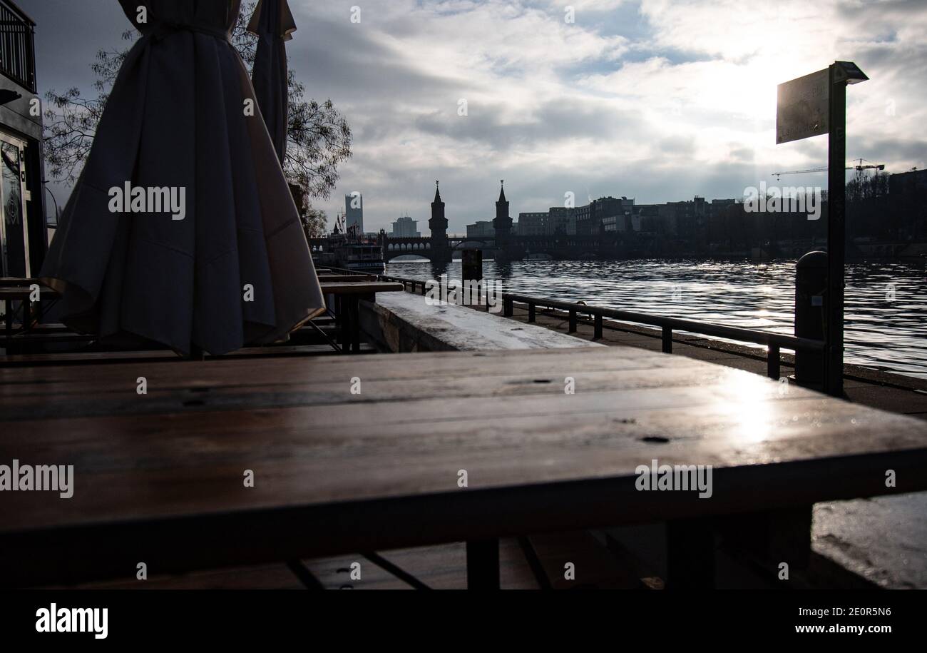 02 January 2021, Berlin: The area on the Spree not far from the Oberbaumbrücke is deserted, the outside area of a restaurant is cordoned off. Photo: Paul Zinken/dpa Stock Photo