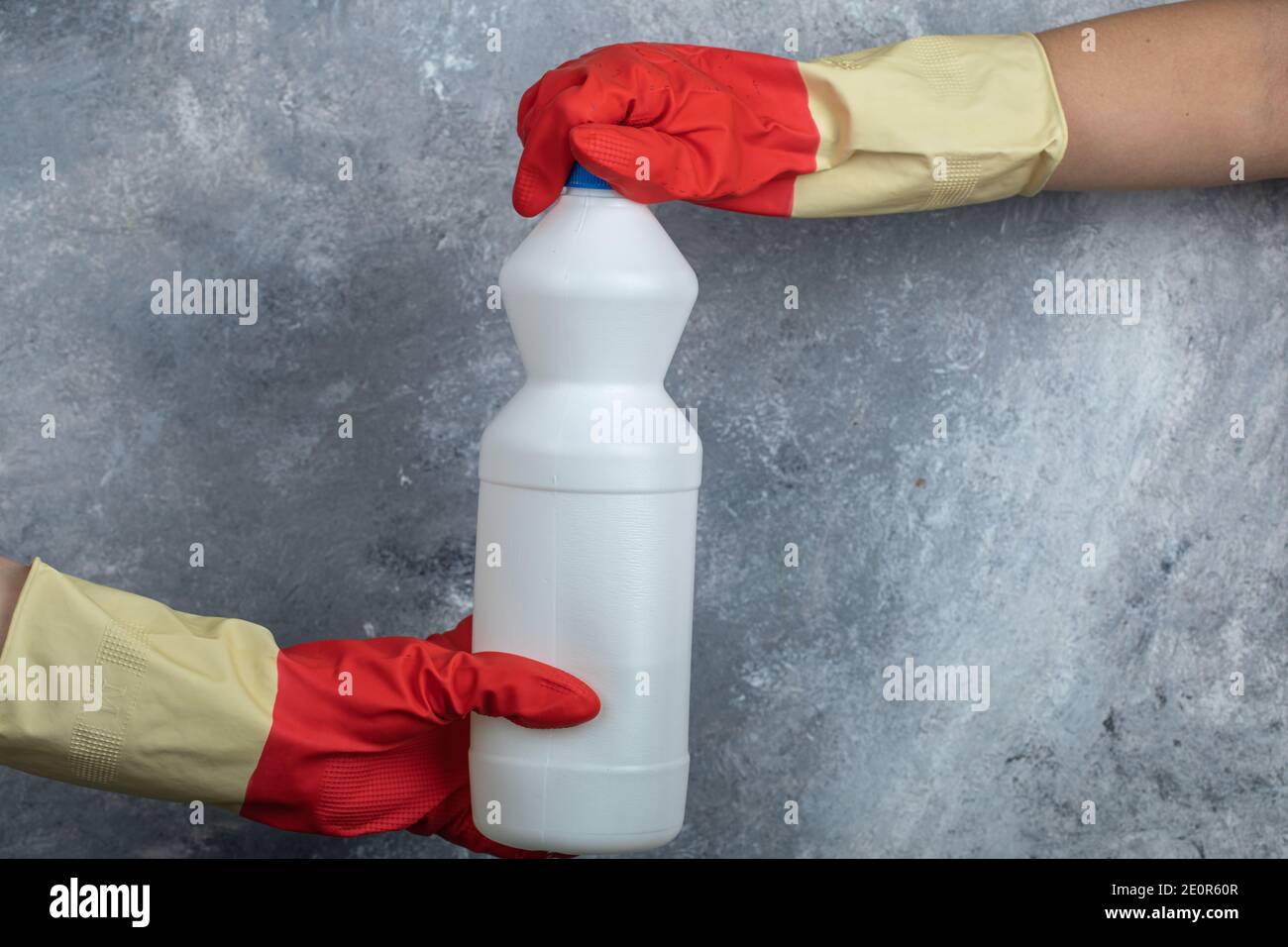 Hands in red gloves holding bleach on marble background Stock Photo Alamy