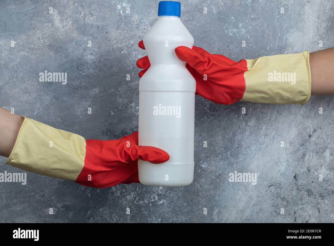 Hands in red gloves holding bleach on marble background Stock Photo Alamy