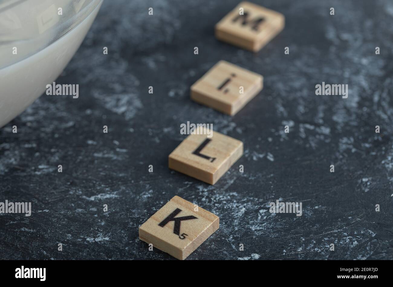 Bowl of milk and wooden letters spelled as milk Stock Photo