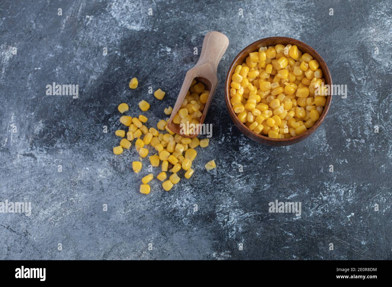 Spoon and bowl of sweet corns on marble background Stock Photo