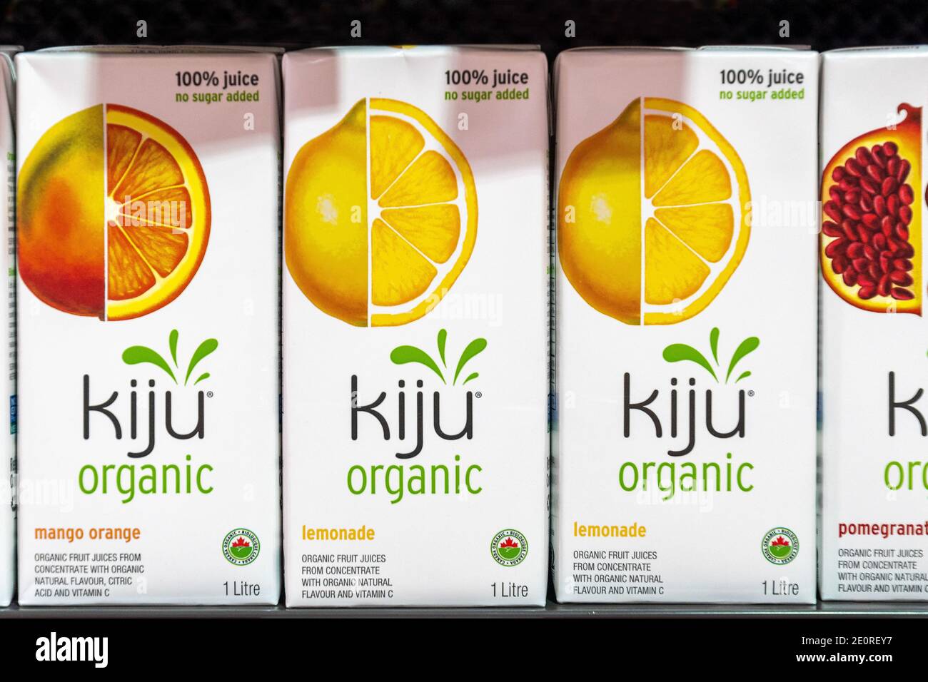Boxes of Kiju branded organic juice. There are flavors of Mango, Lemonade, and Pomegranate.  The boxes are seen on a store shelf. There are no people i Stock Photo