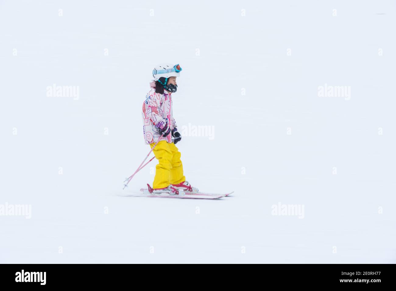 A child descends ski slopes in Niseko, Hokkaido, Japan Stock Photo