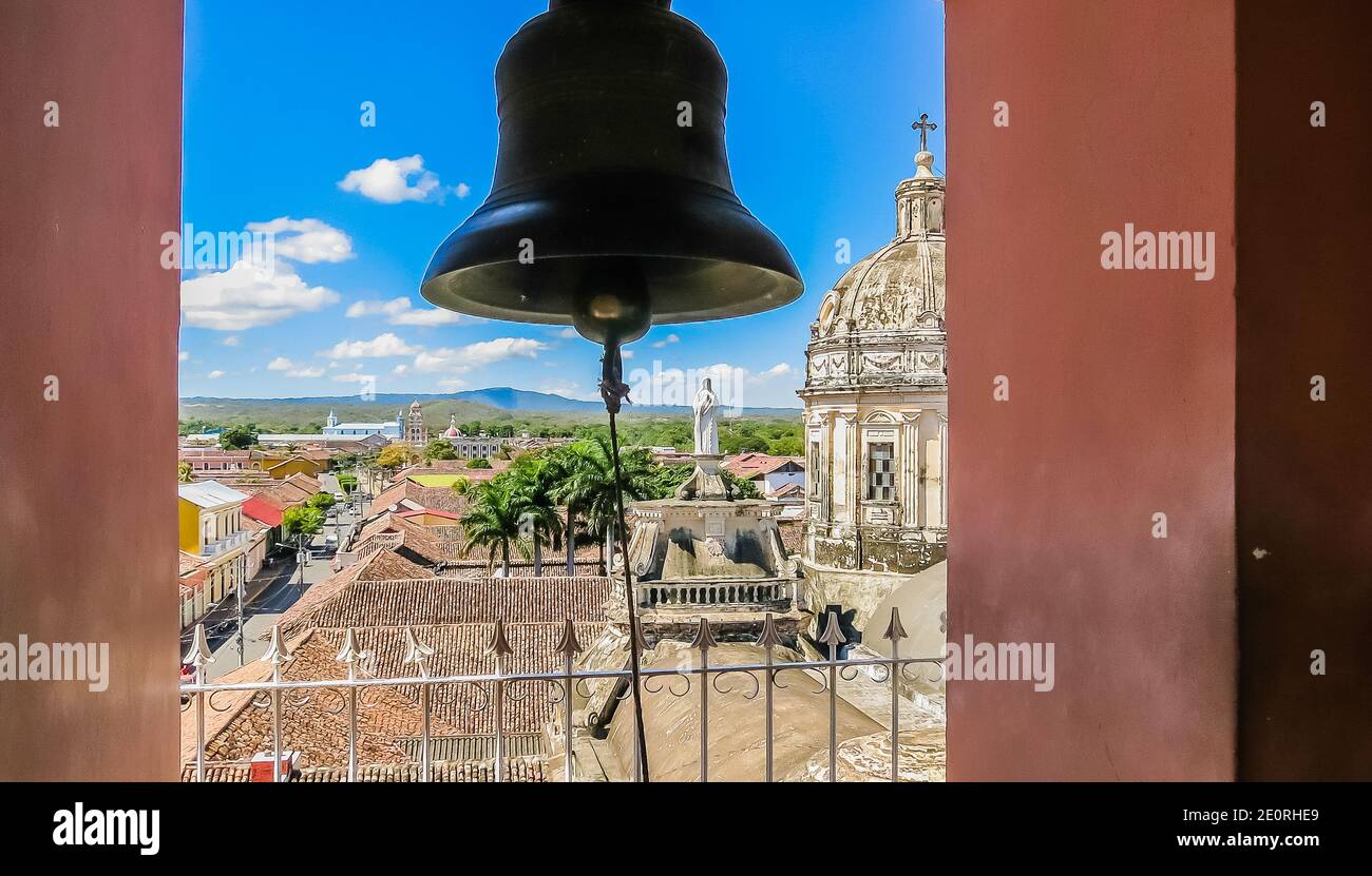 View of the Granada city through the arch of the bell tower of La Merced Church along the street Calle Real Xalteva with Iglesia de Xalteva catholic c Stock Photo