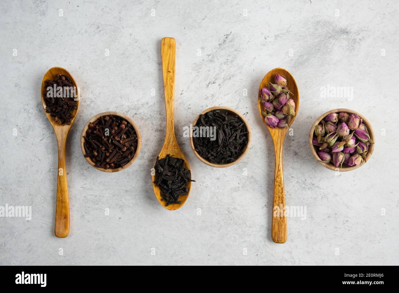 Different spices in wooden spoons and bowls Stock Photo