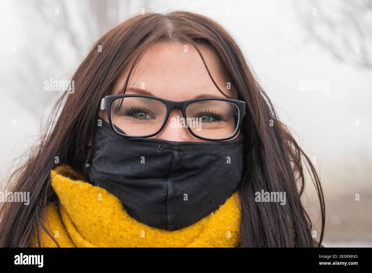 Young woman with beautiful eyes and wearing mask in times of Corona Stock Photo