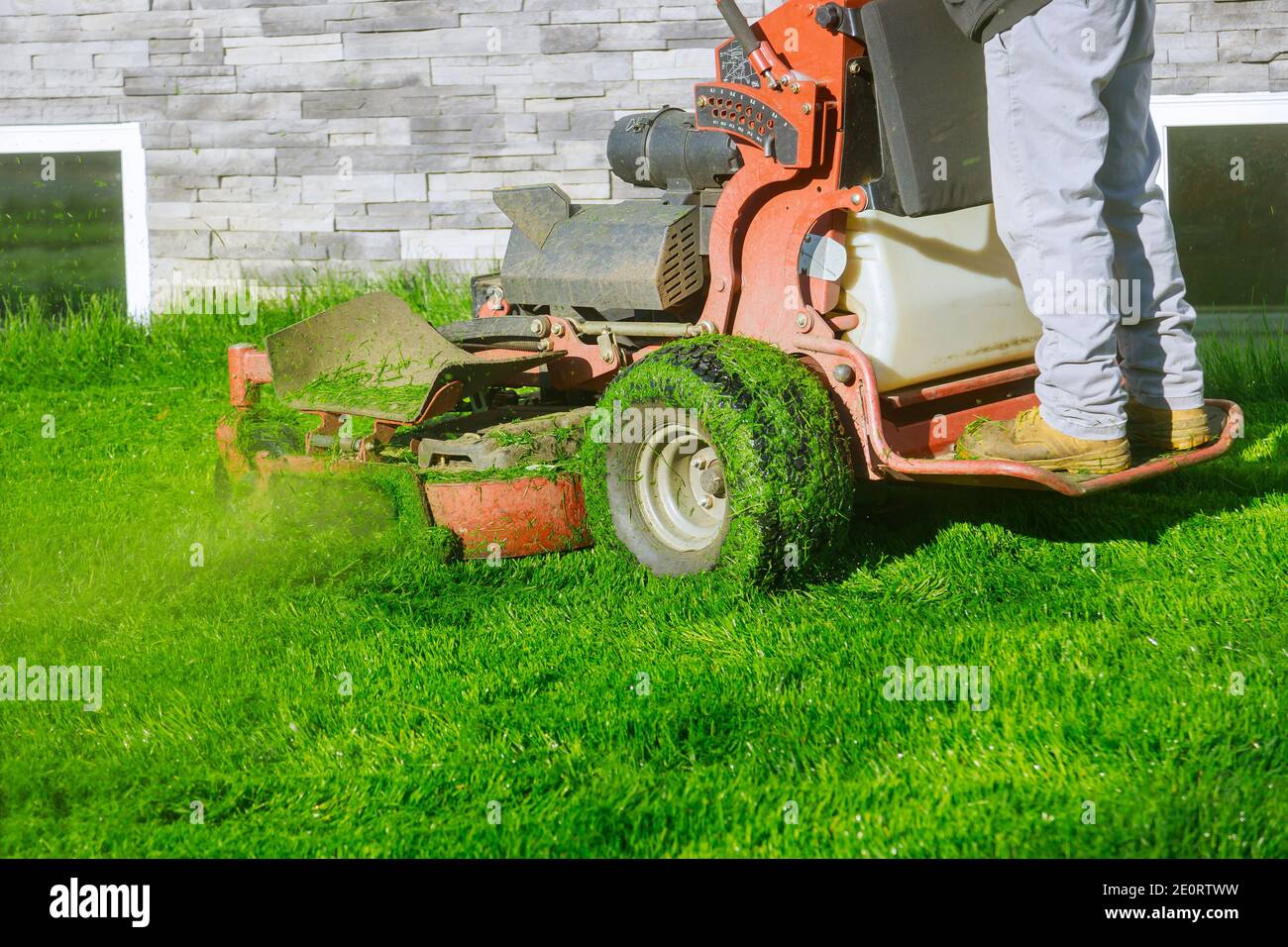 Cutting the grass gardening own home yard with lawn mower Stock Photo