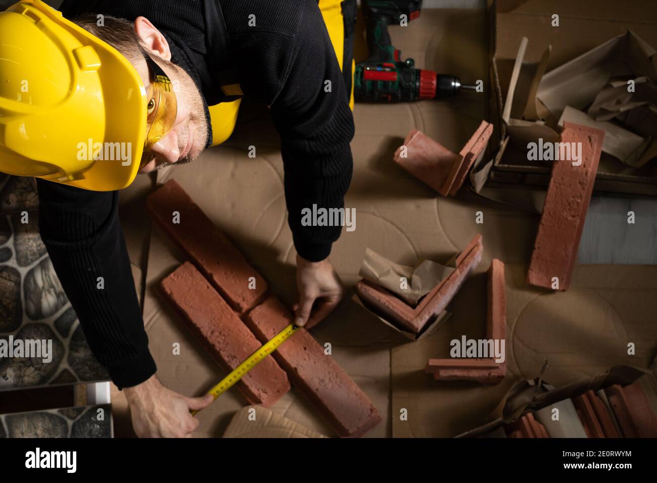 While measuring with a pull-out measure, a manual worker found time to smile and enjoy the job he is doing. Stock Photo