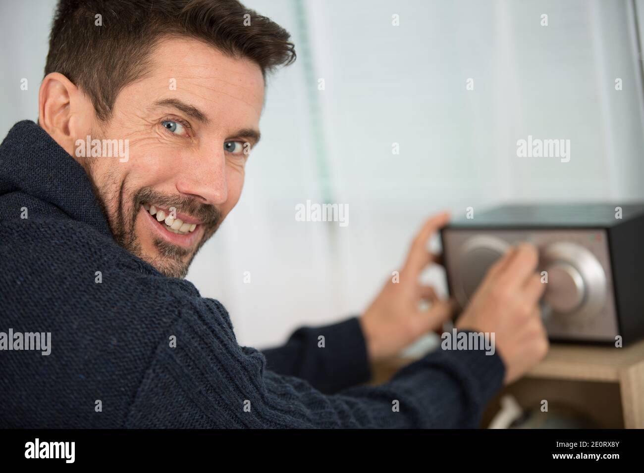 happy man listens at home to a radio broadcast Stock Photo