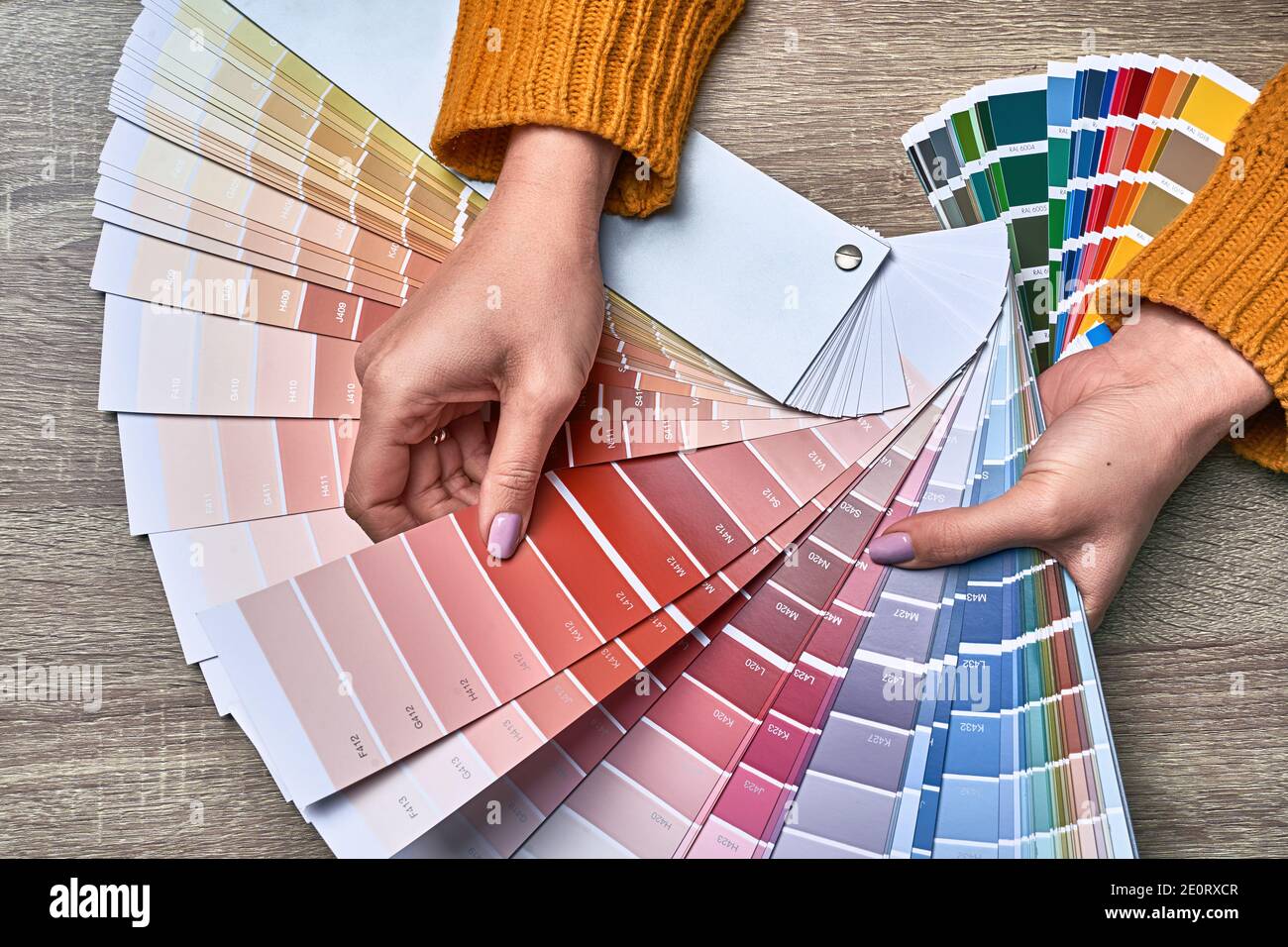 Color wheel for choosing paint tone. Hands of female interior designer