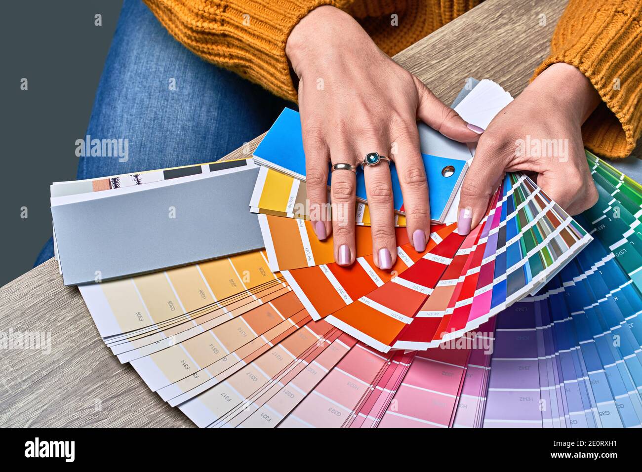 Color wheel for choosing paint tone. Hands of female interior designer