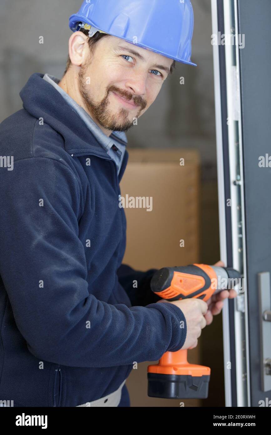 contractor using cordless screwdriver on door frame Stock Photo