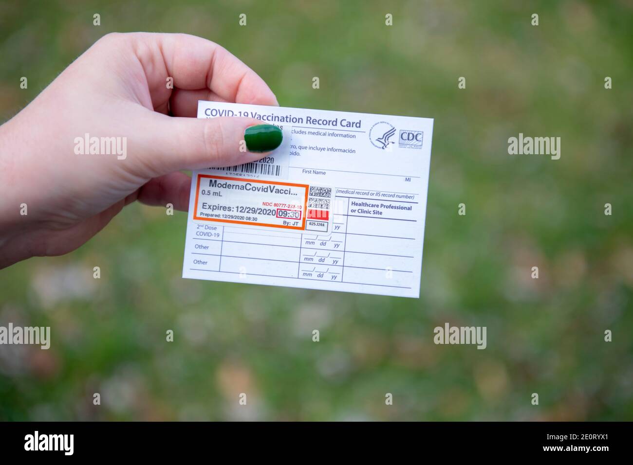 Woman holding a Covid 19 Moderna Vaccine Card for proof of the first dose issued by the CDC USA Government Stock Photo