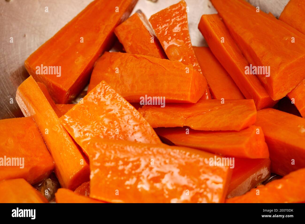 Cut sweet potato, oiled and salted, prepared for roasting Stock Photo