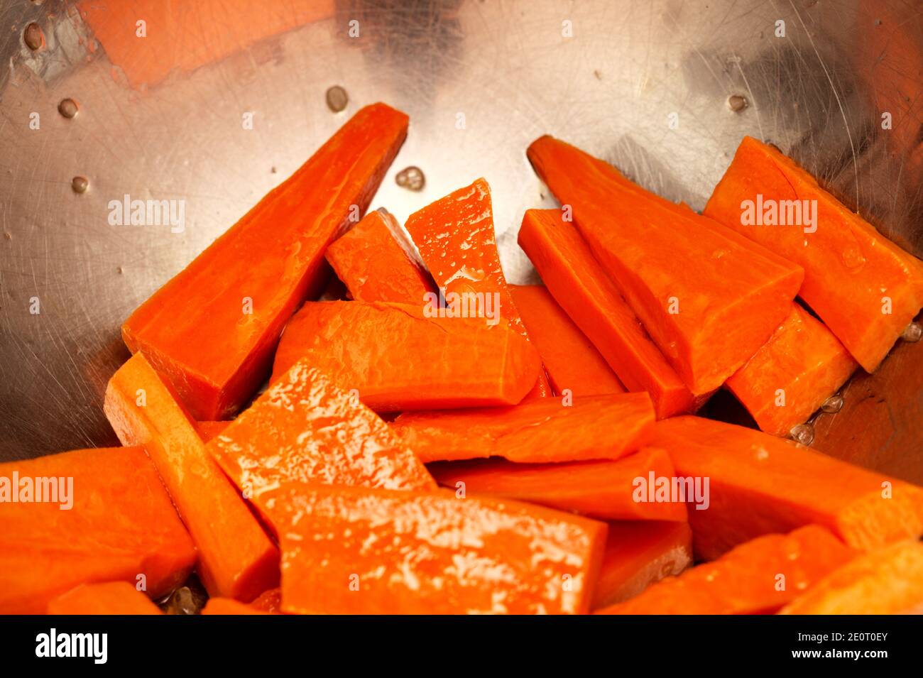 Cut sweet potato, oiled and salted, prepared for roasting Stock Photo
