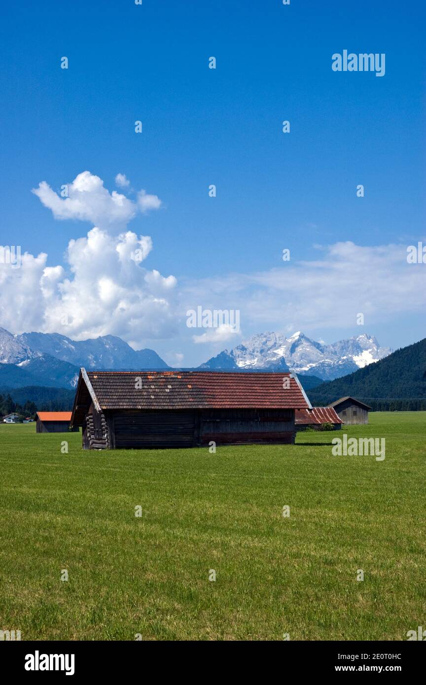 Pasture and cattle shelters in an Alpine valley outside Hallein, Austria with the Alps on the horizon. Stock Photo