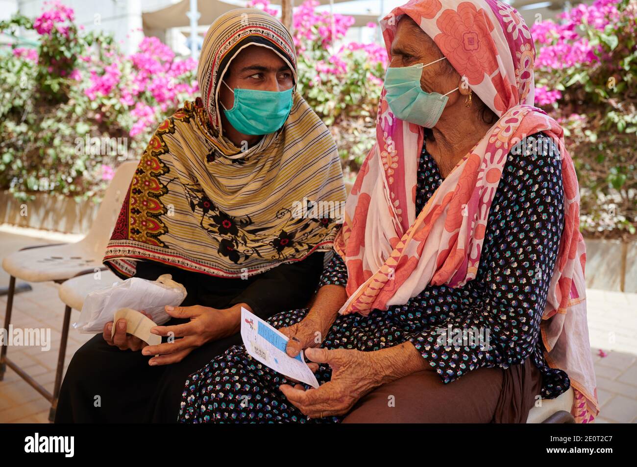 Amidst the coronavirus pandemic, Shehnaz, speaks with her aunt Kaneez Fatima, 60, a TB client regarding a coronavirus test, at the Gori TB Clinic at the Indus Hospital in Korangi, Karachi, Pakistan. Stock Photo