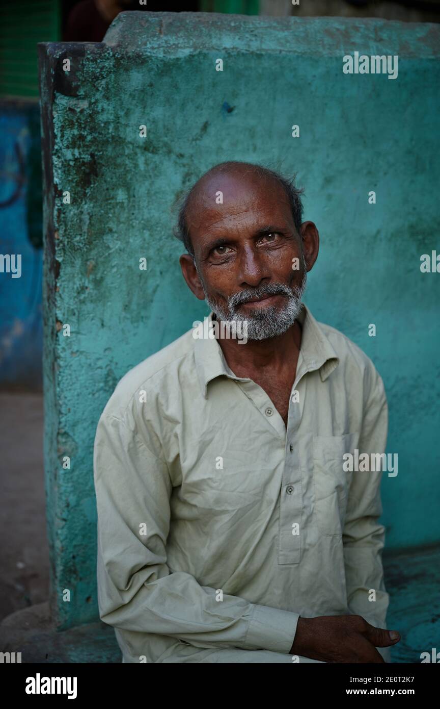 Amidst the coronavirus pandemic that continues to rise in the country rapidly, an old man smiles outside a store in Kimari neighbourhood in Karachi, the main port city of Pakistan. Stock Photo