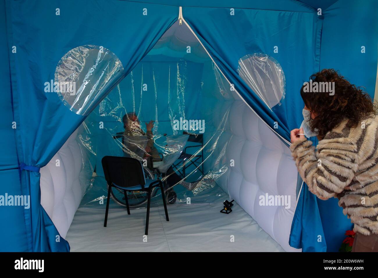 Serino, Italy. 02nd Jan, 2021. Family members hug each other inside a hug room set up at the Santa Lucia Home in Serino, Campania region, southern Italy. The hug room in Campania was an initiative of to allow, after long months of isolation due to the restrictive anti-COVID-19 measures, the elderly guests of the social welfare structures to meet their families closely and be able to hug and hold each other hands. Credit: Independent Photo Agency/Alamy Live News Stock Photo