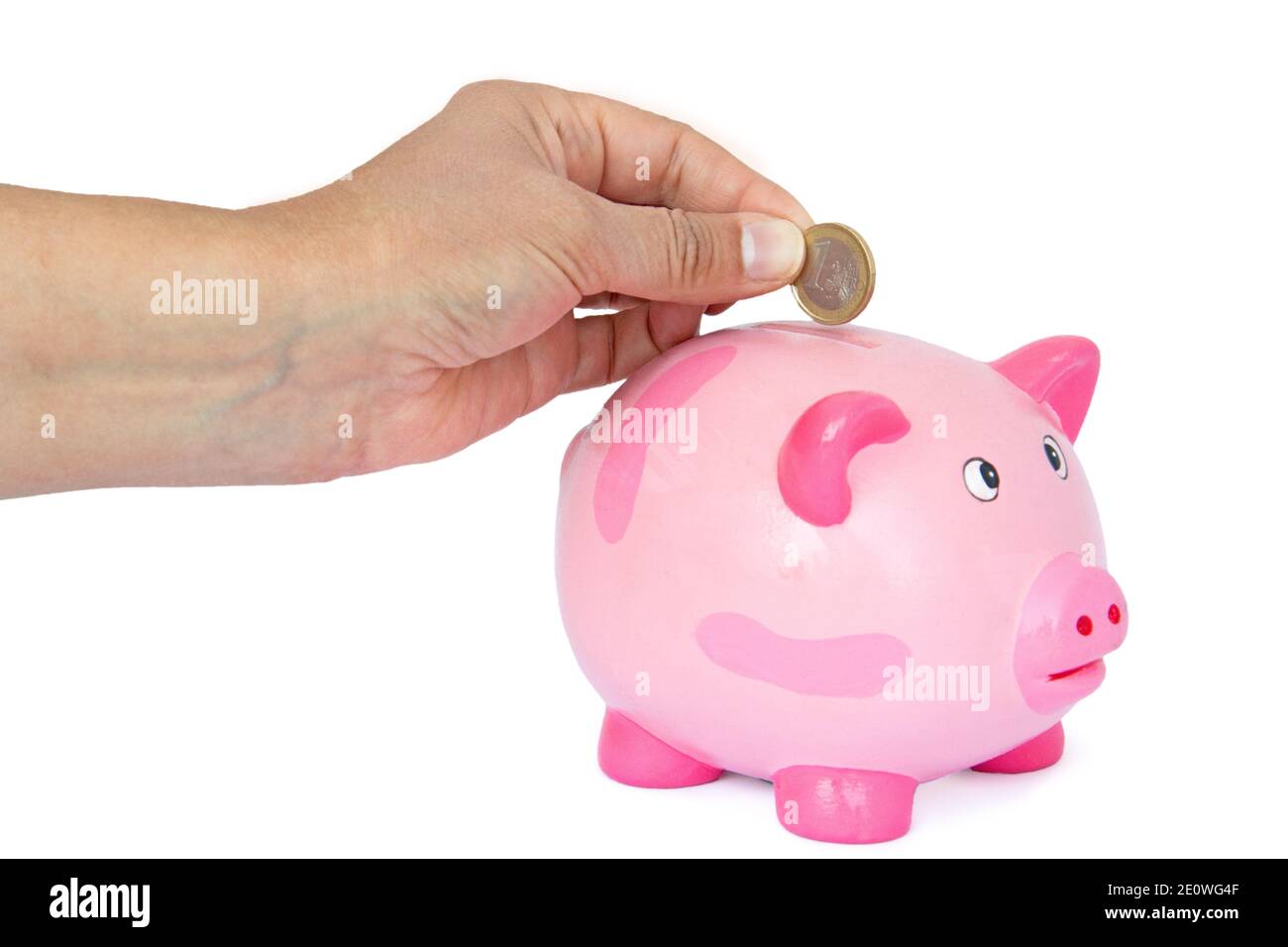 Hand Throwing Euro Coin Into A Piggy Bank Stock Photo - Alamy