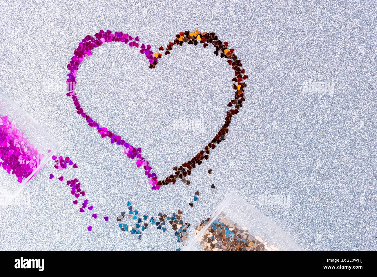 Heart shape made of multicolored glitter. Two champagne glasses with splash  of heart shaped confetti over ultimate gray glitter background. Valentine'  Stock Photo - Alamy