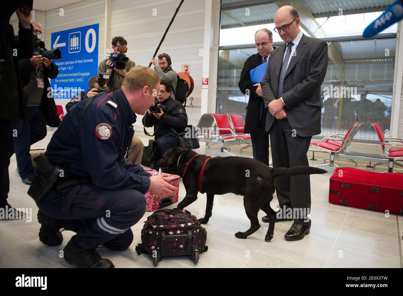 French Minister Of The Economy Finance And Foreign Trade Pierre Moscovici Listens To A Customs Officer S Explanations On The Sniffer Dogs Tasks During His Visit To The French Customs Service At Orly S