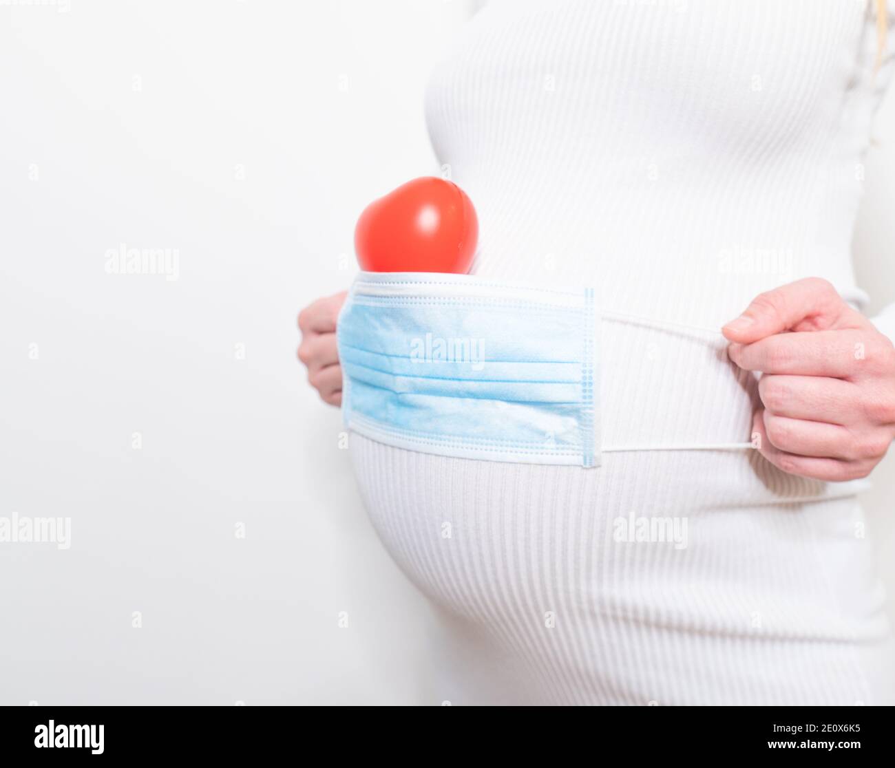 Pregnant mother use face mask covering on her abdomen for protecting