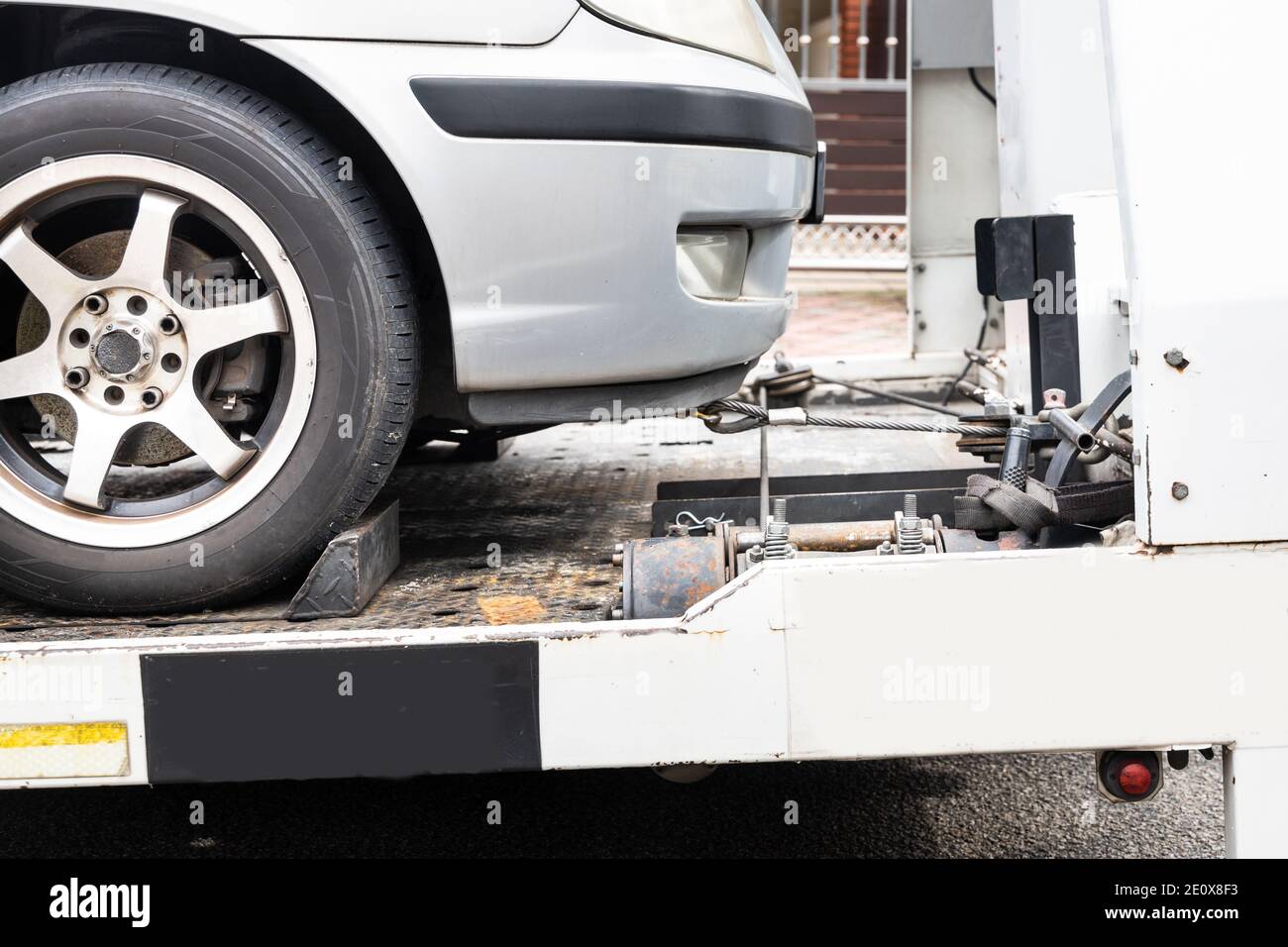 Broken down car towed onto flatbed tow truck Stock Photo