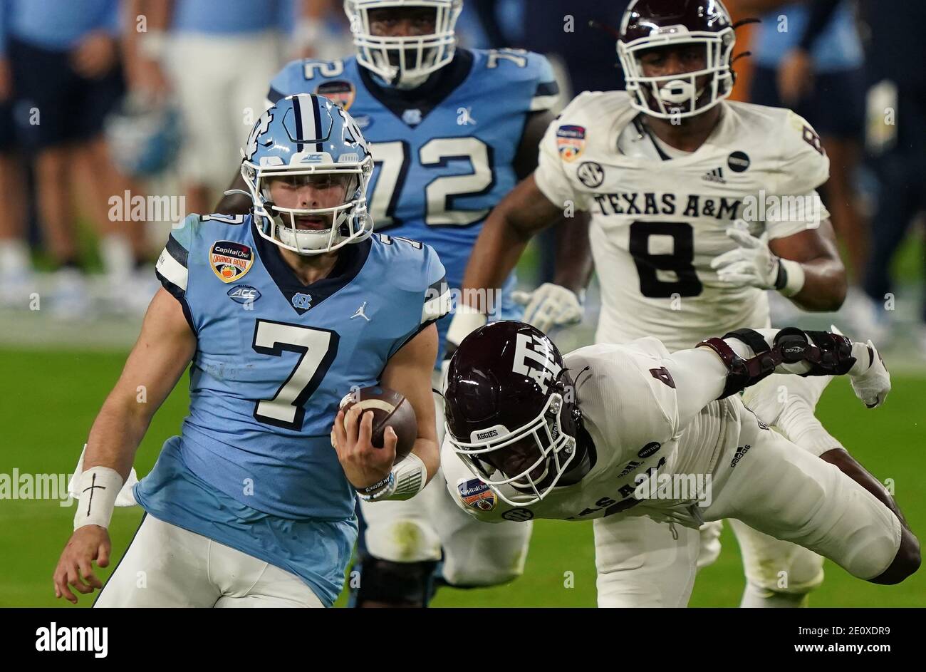Miami, United States. 02nd Jan, 2021. North Carolina Tar Heels quarterback Sam Howell (7) evades Texas A&M Aggies defensive back Erick Young (R) and DeMarvin Leal (8) on a short run during the first half of the Orange Bowl, in Miami on Saturday, January 2, 2021. Photo by Hans Deryk/UPI Credit: UPI/Alamy Live News Stock Photo