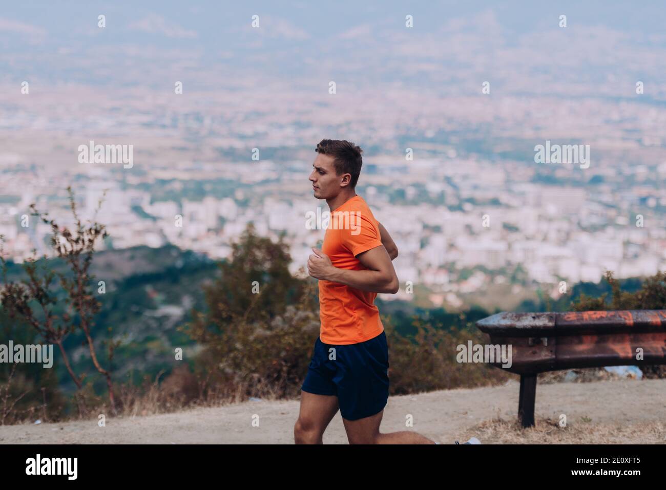 Athletic fit young sport fitness model in his twenties in full body length on road outside in mountain Stock Photo