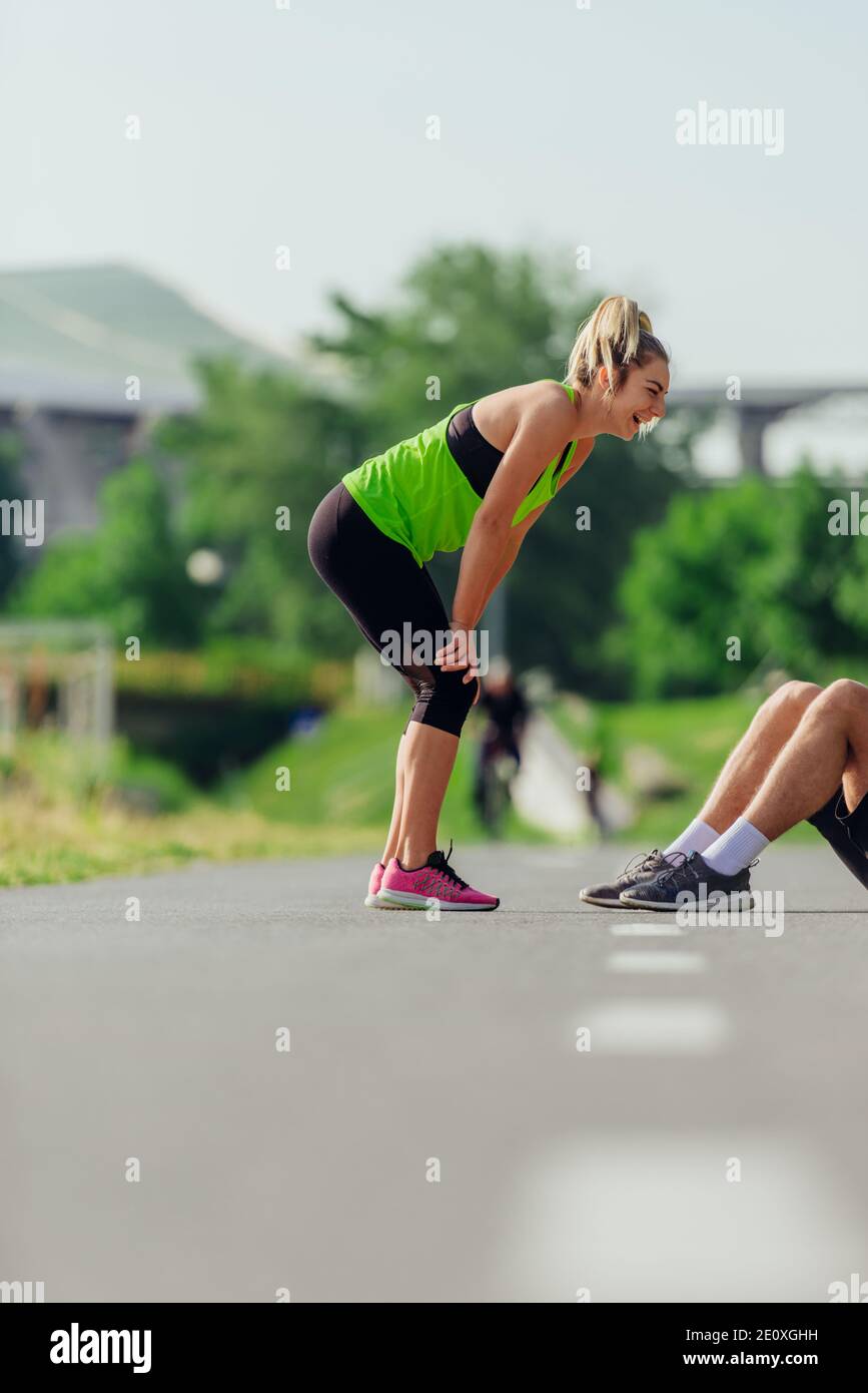 Sportswoman taking a break on the running road track and resting after ...