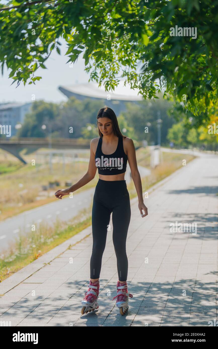 Healthy young woman learning to ride on roller skates and how to keep