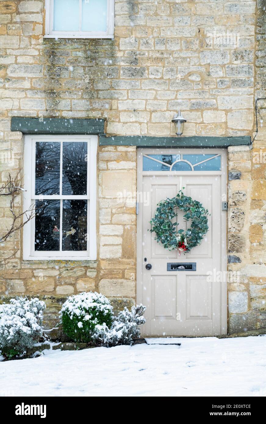 Christmas wreath on a cottage door in the snow. Burford, Cotswolds
