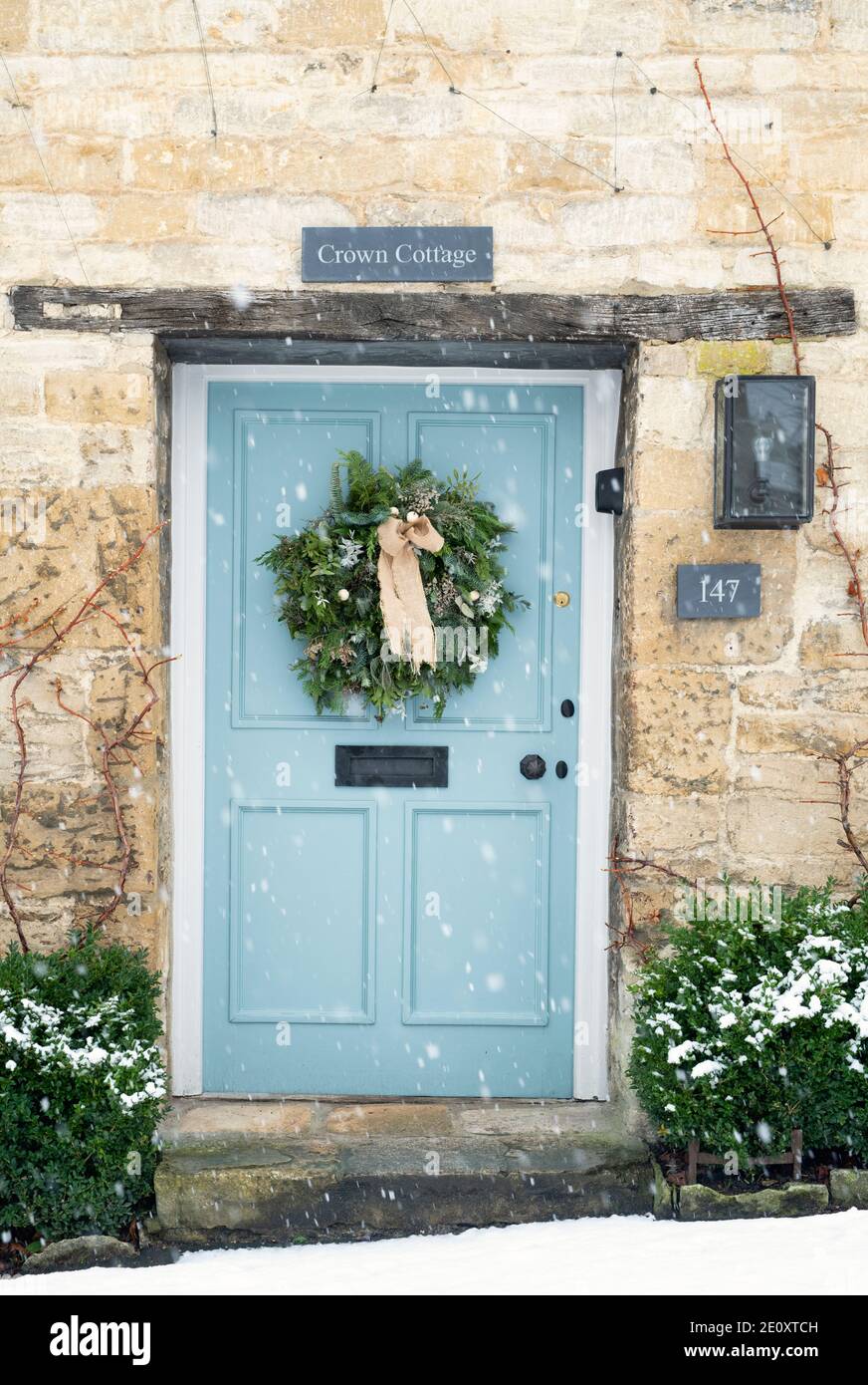Christmas wreath on a cottage door in the snow. Burford, Cotswolds