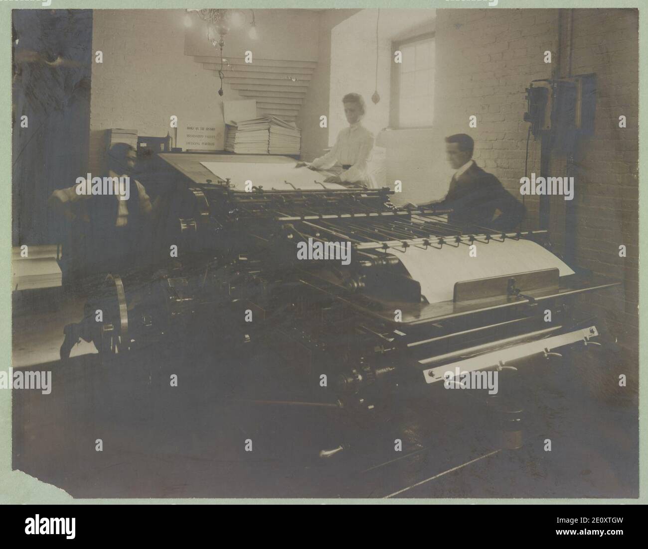 Librarians Feeding Large Sheets Of Paper Through A Machine At The Card Librarians feeding large sheets of paper through a machine at the card