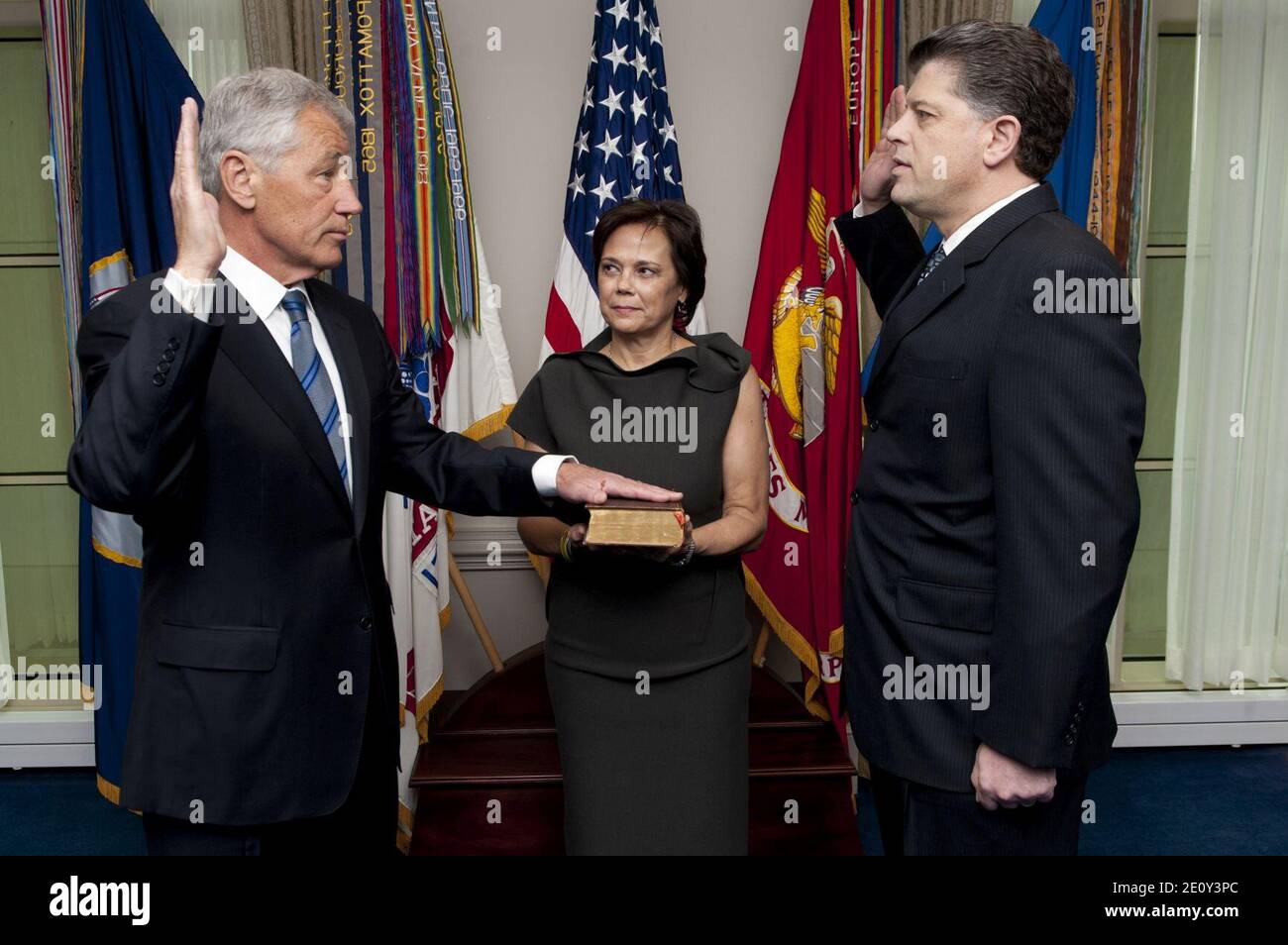 Lilibet Hagel, center, holds the Bible for her husband Chuck Hagel, left, as he is sworn into office as the 24th Secretary of Defense by DoD Director of Administration and Management Michael L. Rhodes, right Stock Photo