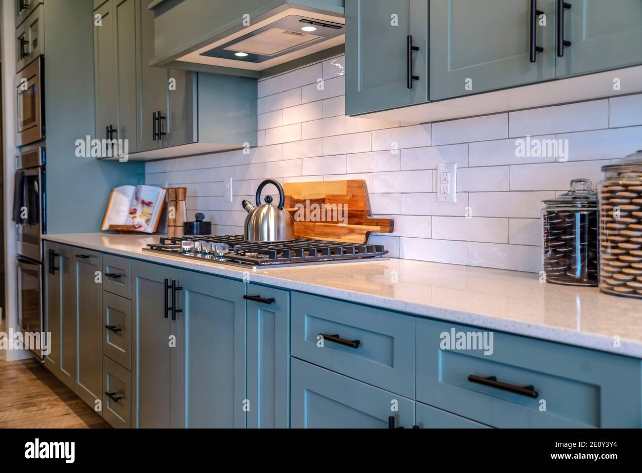 Cooking area of home with and exhaust hood over cooktop and