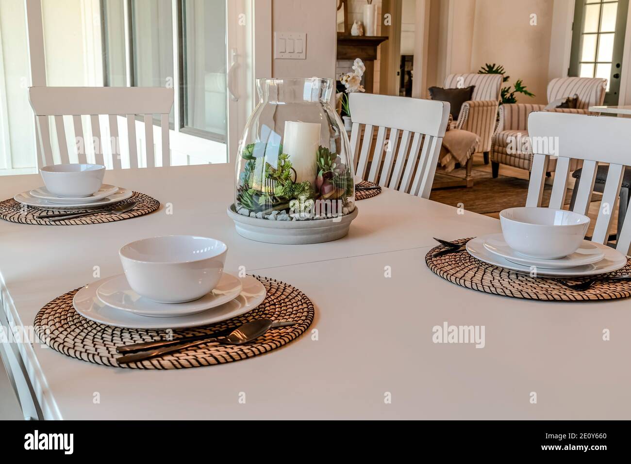 Tableware on dining table set for four persons with living area in background Stock Photo