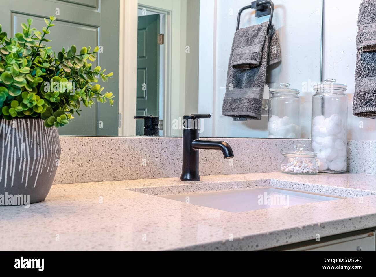 Single white sink with black faucet built on the countertop of bathroom