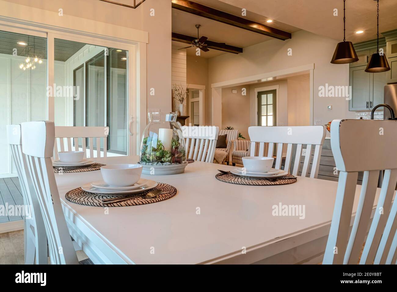 Dinner table for four persons with living area and kitchen view in background Stock Photo