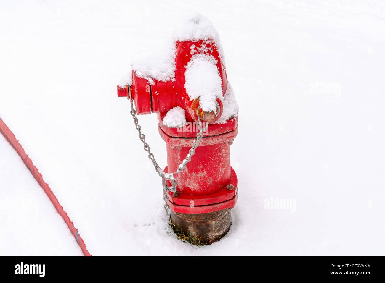 Old fire hydrant with bright red paint on a snowy and frosty winter setting Stock Photo