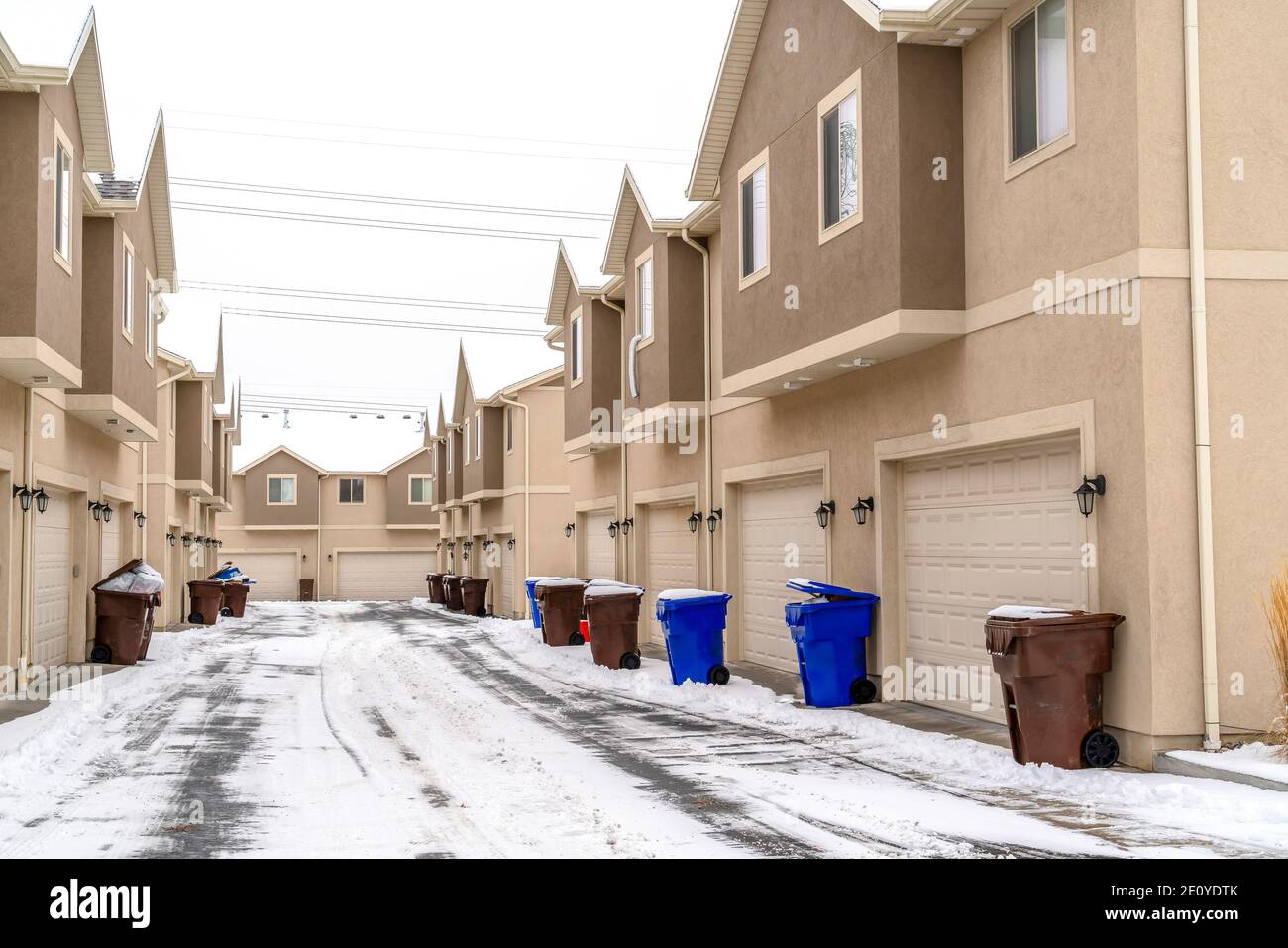 Apartments exterior with trash cans on the snowy road in front of ...