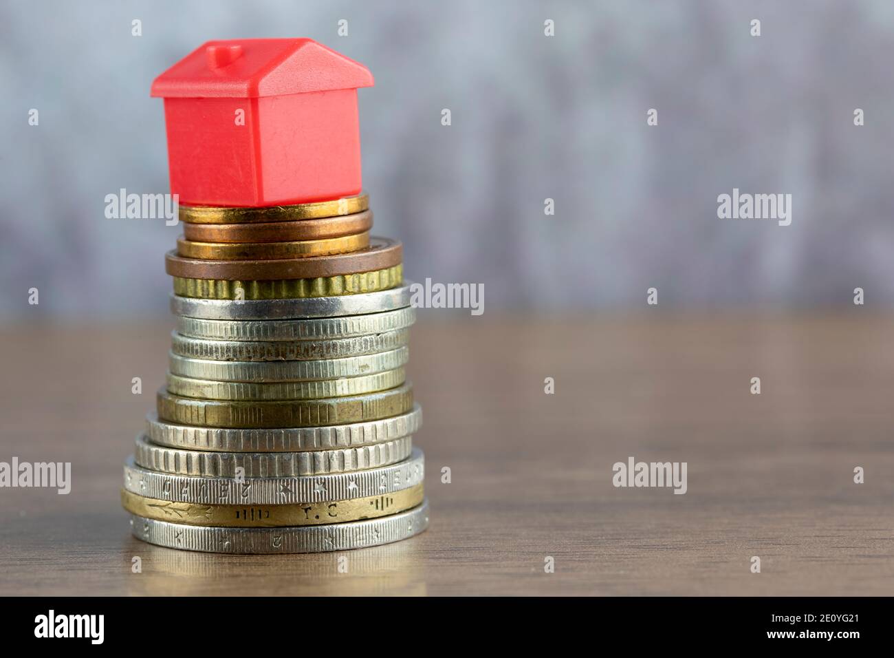 House is sitting on top of a coin stack, Real Estate and Savings ...