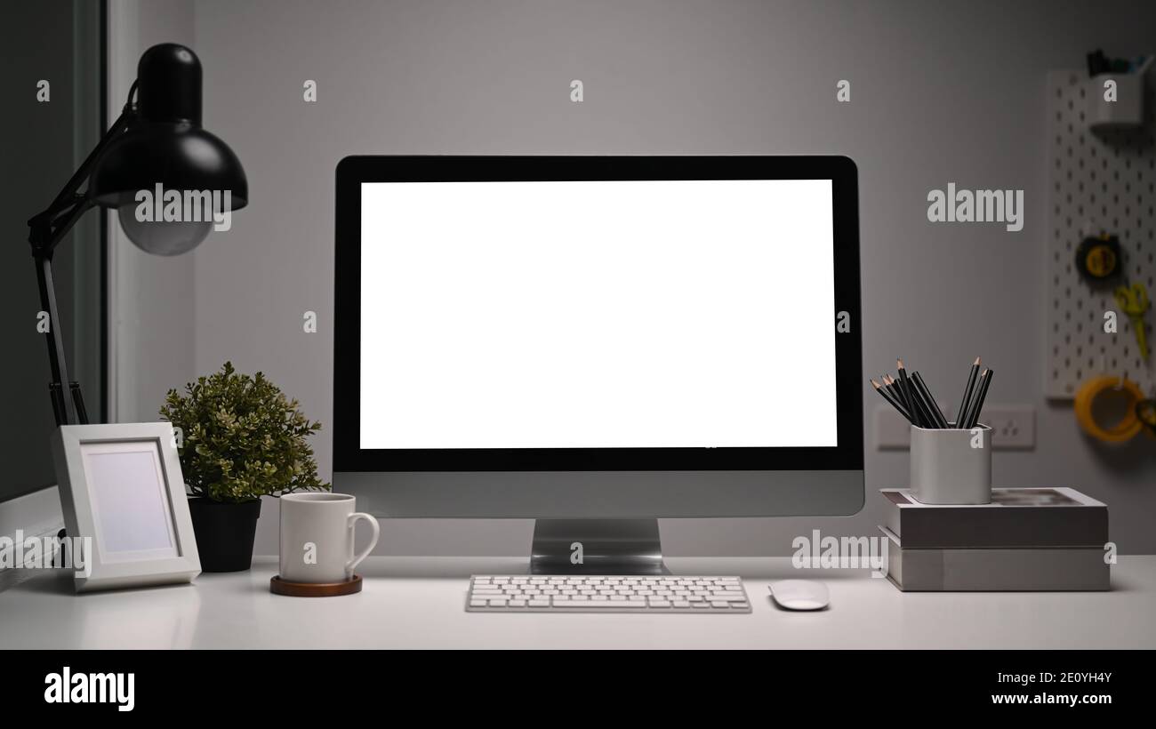 Front view of office desk with blank computer and various office tools on  white table Stock Photo - Alamy