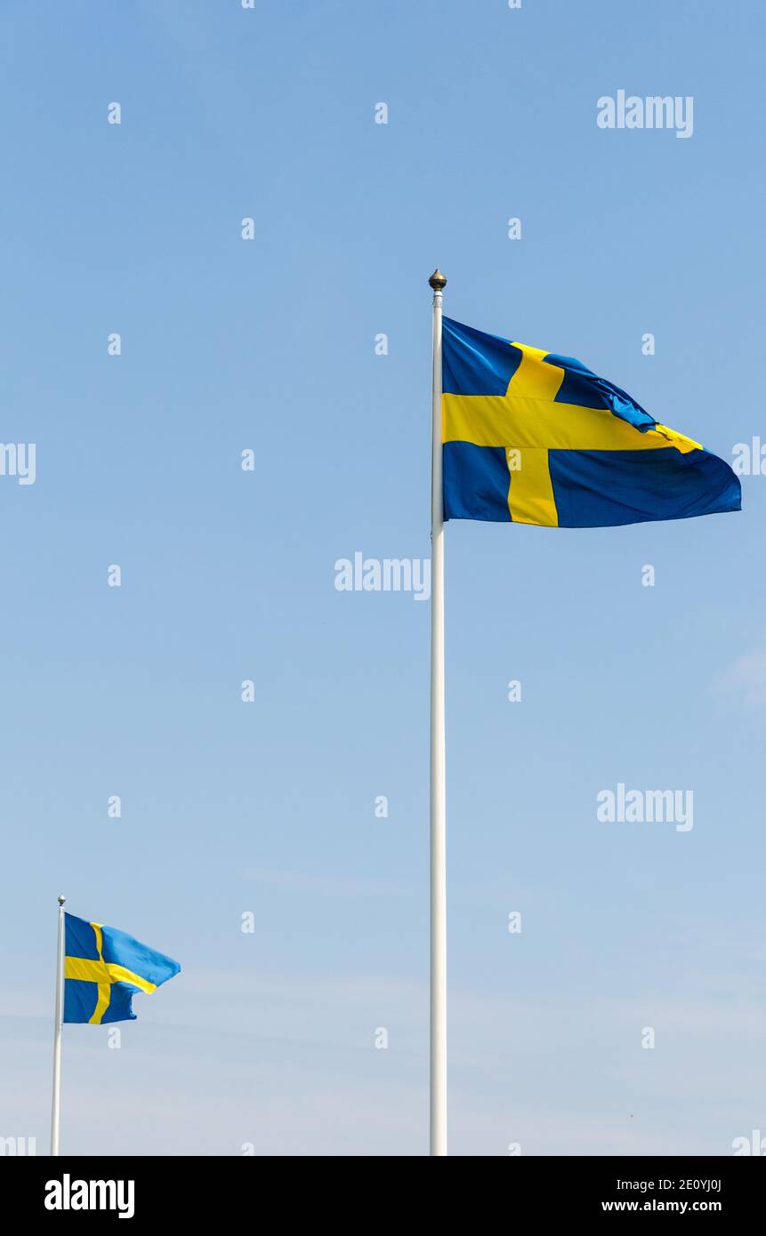 Waving Swedish flags by a blue sky Stock Photo